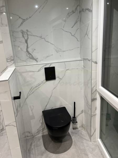 WC suspendu carrelé effet marbre blanc avec détail noir à proximité de Strasbourg