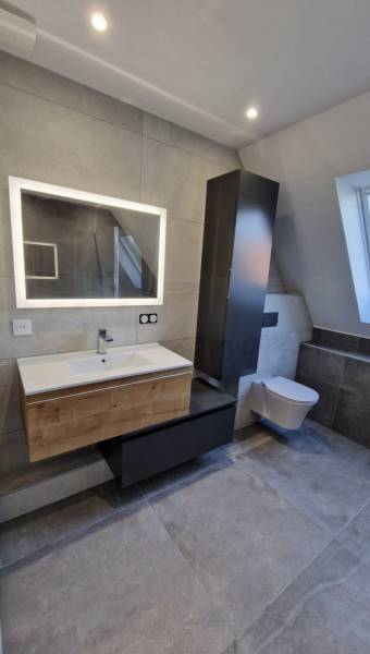 Pose d'un meuble vasque effet bois avec un sous meuble de rangement noir, une colonne de rangement noire et un WC suspendu à Herrlisheim